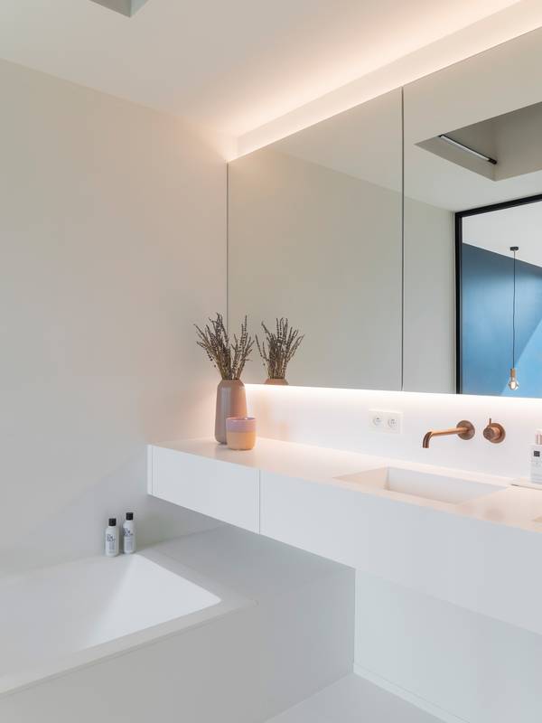 witte badkamer met bad en wastafel